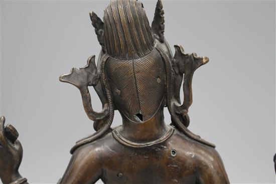 A Sino-Tibetan bronze figure of a seated female deity, on associated marble plinth, height 35cm